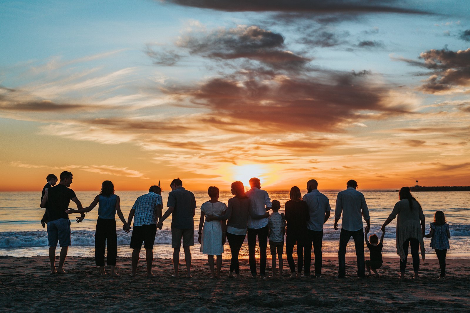 A family of all ages watching the sunset together on the beach